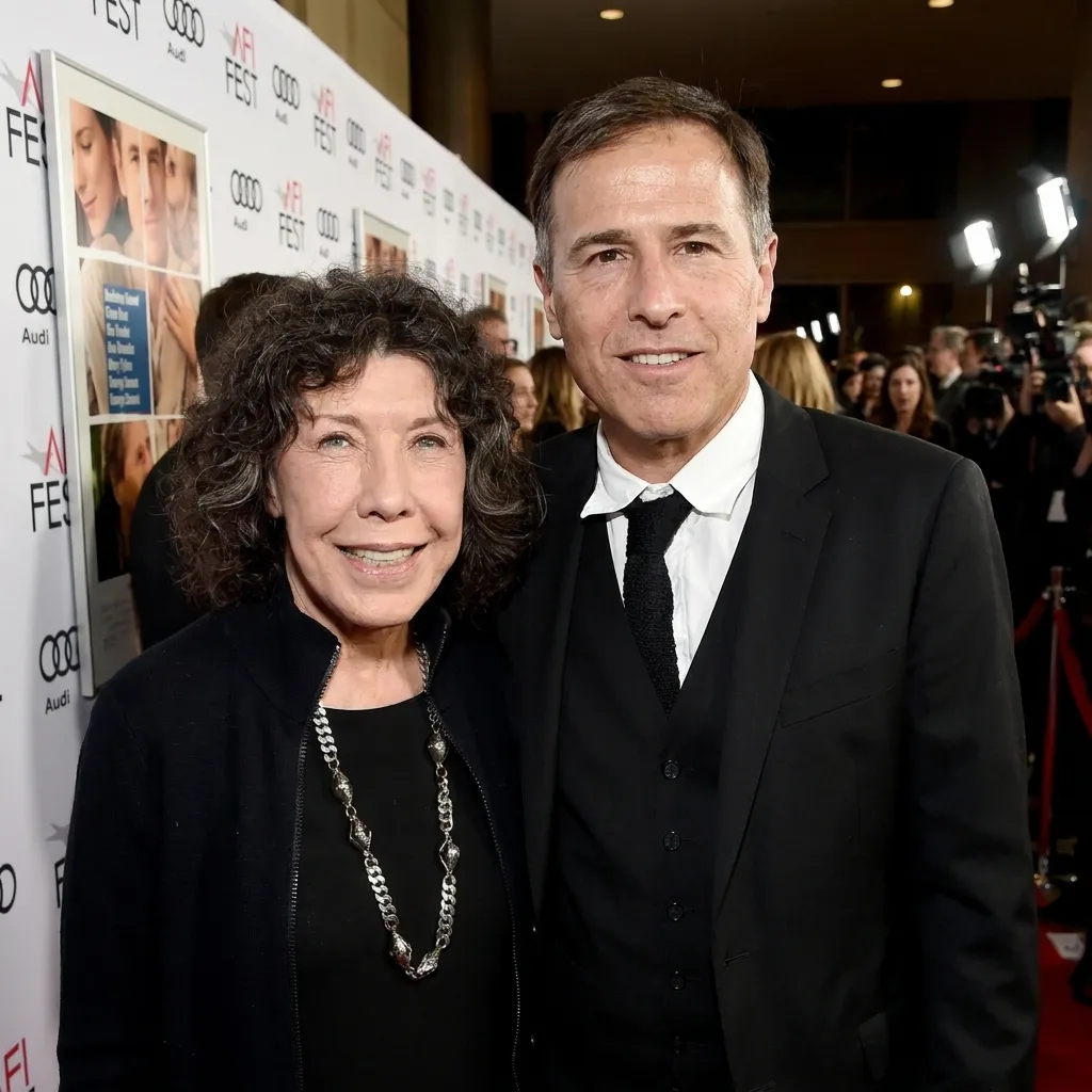 Actress Lily Tomlin and director David O. Russell posing for photographers on the red carpet at an AFI Fest premiere event.