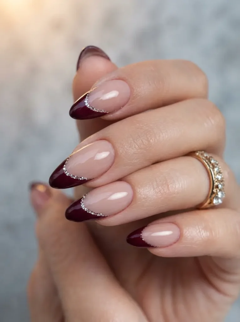 Burgundy almond French manicure accented with a sparkling silver glitter line.