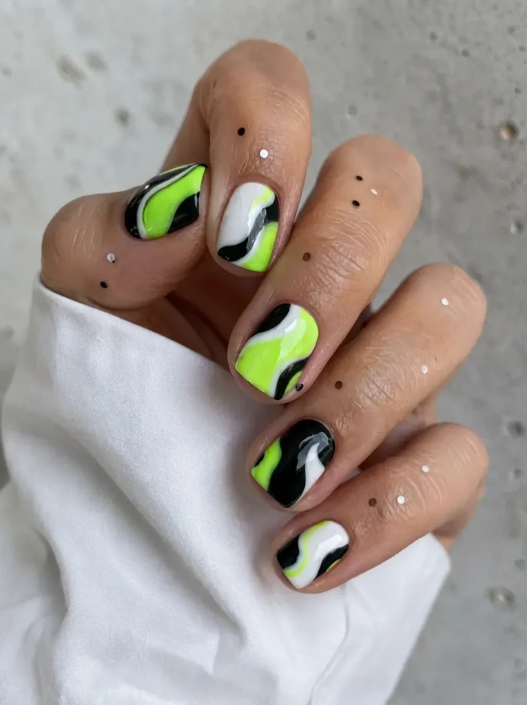 Short square nails featuring a modern abstract design with neon green, black, and white fluid swirl patterns.