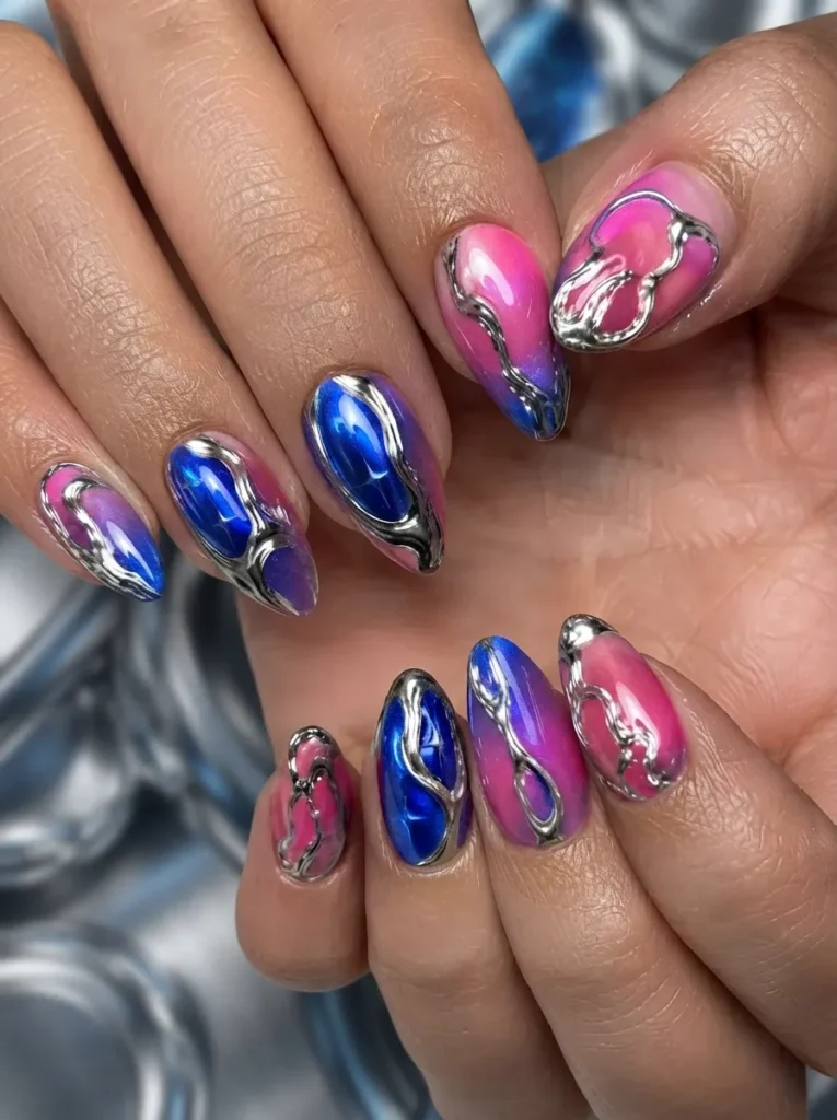 Close-up of pink and blue gradient ombre nails adorned with abstract 3D liquid silver chrome fluid art.