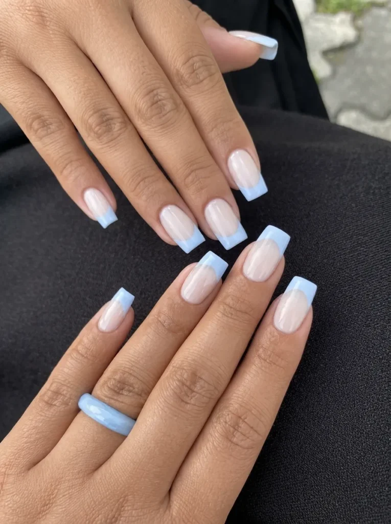 Square-shaped nails with classic light blue French tips on both hands