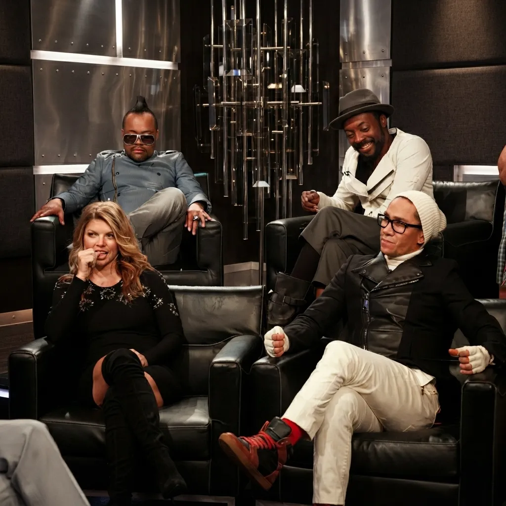 The members of the Black Eyed Peas relaxing and sitting in leather armchairs in a studio setting.